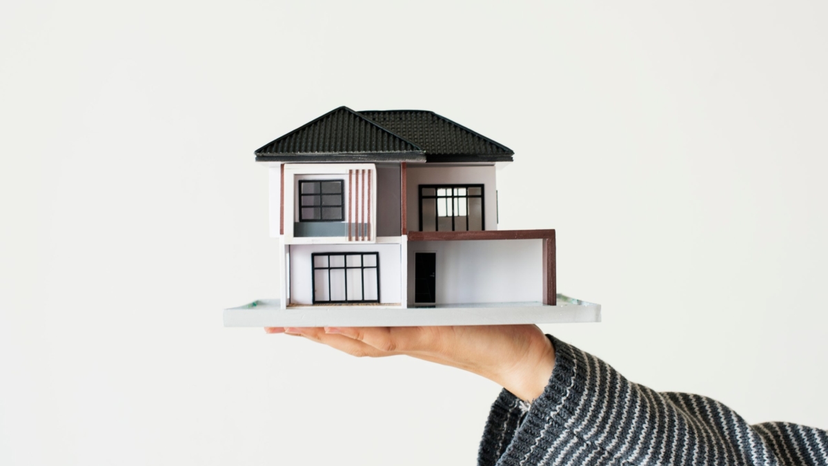 Hand presenting model house for home loan campaign