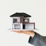 Hand presenting model house for home loan campaign